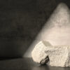 Rough stone with sunlight from window on concrete wall and floor