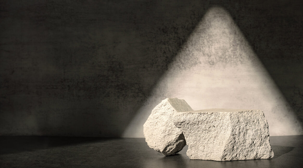Rough stone with sunlight from window on concrete wall and floor